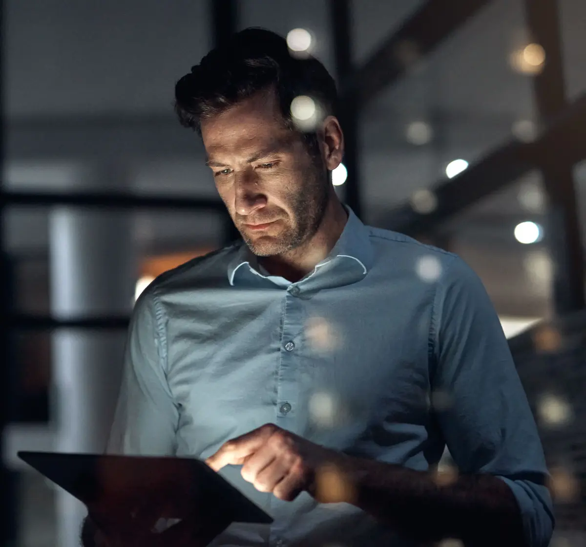 A man working on a tablet at night