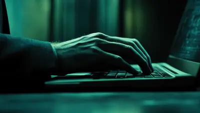 Person tippt auf Laptop Tastatur