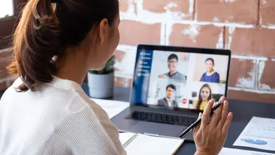 Femme devant son écran d'ordinateur, participant à un réunion en visio