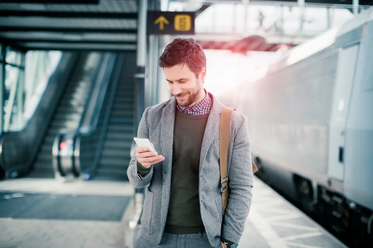 Un homme consulte son mobile dans un aeroport