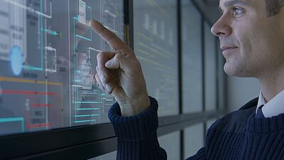Un homme devant un écran technologique