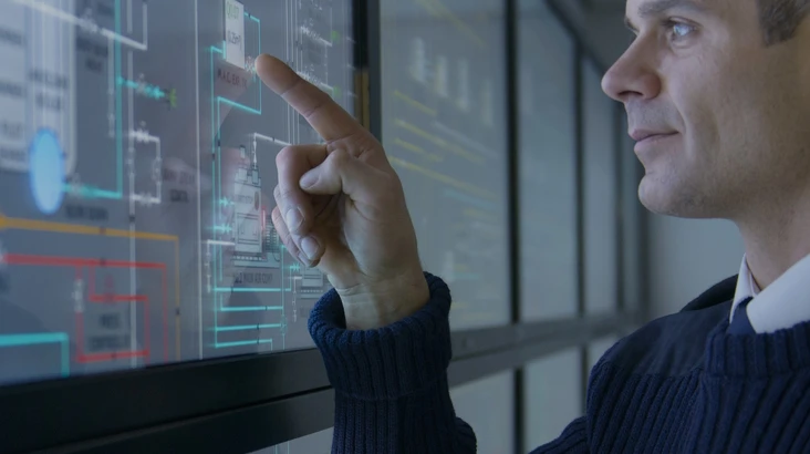 Un homme devant un écran technologique