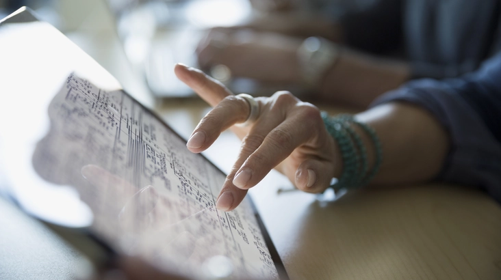 Close-up of a woman's hand using a tablet.