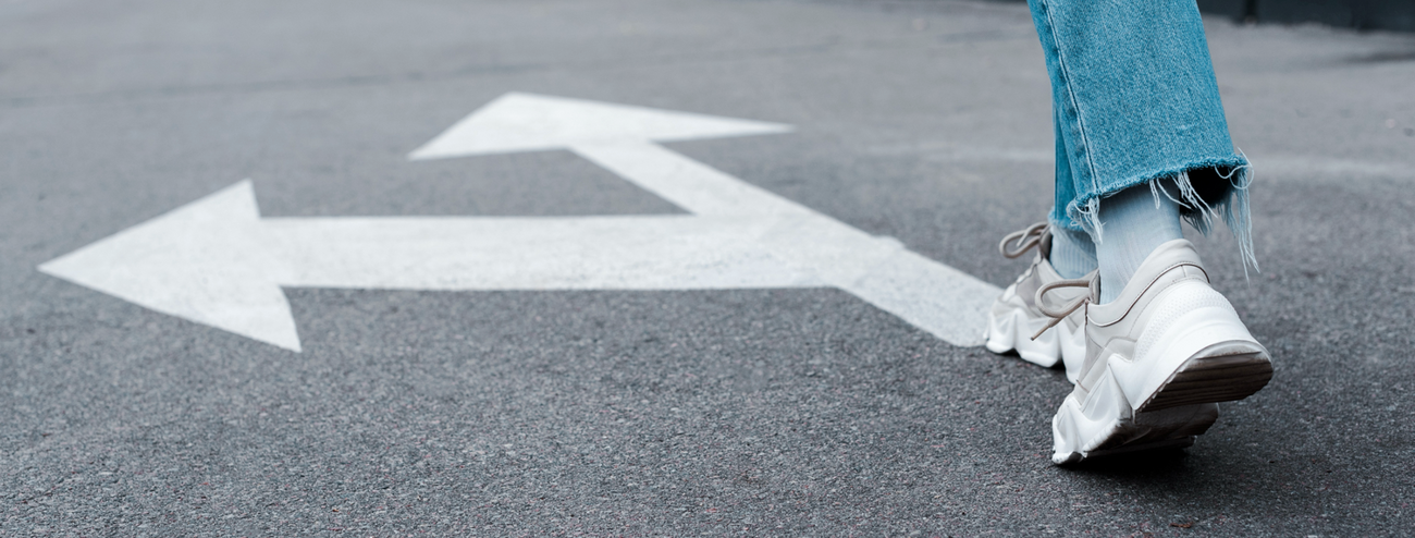 Walking legs on a road with a directional arrow
