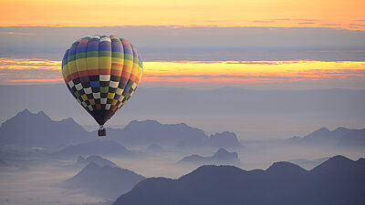 Hot air balloon in the mountains at sunset