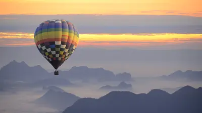 Hot air balloon in the mountains at sunset