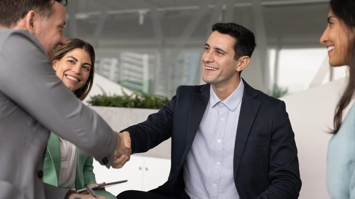 Zwei Männer geben sich im Meeting die Hand