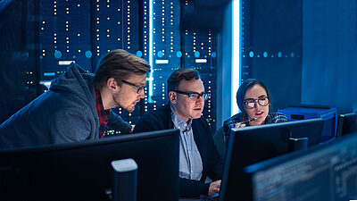 Trois hommes dans des locaux de cybersécurité ou un datacenter