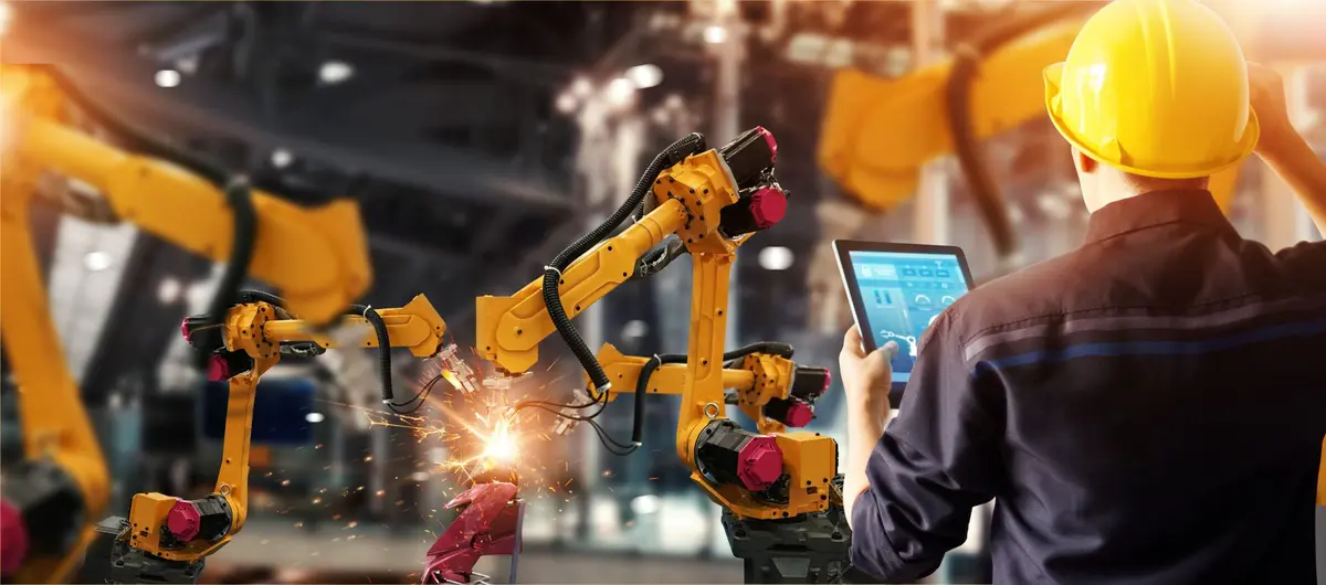 Un ouvrier travaillant sur une chaîne de production industrielle robotisée