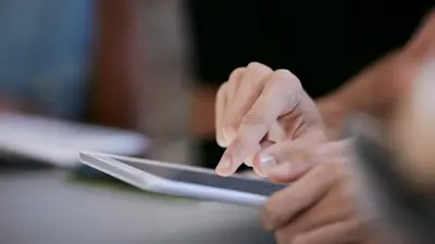 Des mains sur une tablette. 