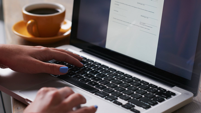 deux mains saisissent des données sur un clavier d'ordinateur