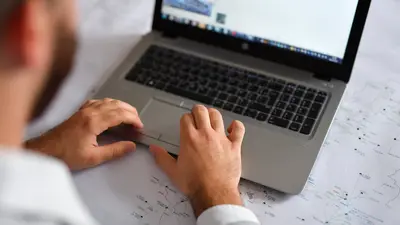 man skriver på laptop