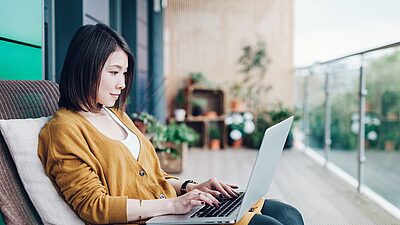 Woman sitting with a laptop on her lap